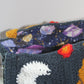 The inside fabric is a purple and blue galaxy with purple tie dye planets, golden constellations and suns, and various white stars.